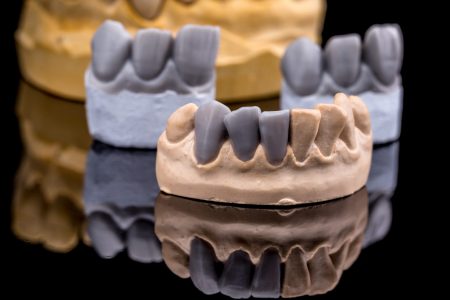 Artificial tooth, wax models on black background